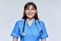 Headshot portrait of nurse in blue uniform looking at camera on light studio background Royalty Free Stock Photo