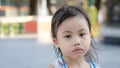 Headshot of sad 4 years old cute baby Asian girl, little toddler child with adorable short hair making frustrated face, looking