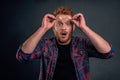 Headshot of shocked and impressed overwhelmed redhead guy with beard, taking off glasses and holding rim on forehead