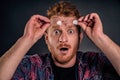 Headshot of shocked and impressed overwhelmed redhead guy with beard, taking off glasses and holding rim on forehead, folding lips