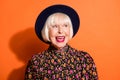 Headshot of sly curious old woman looking blank space smiling red lipstick wearing blouse headwear isolated vivid orange Royalty Free Stock Photo