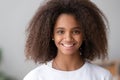 Headshot of smiling cute teenage african girl looking at camera