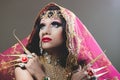 Headshot woman dressed in traditional hindu clothing, heavily decorated in gold and elegant veil, extremely long