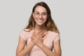 Headshot woman in glasses feels grateful holding hands on chest Royalty Free Stock Photo