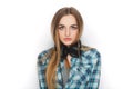 Headshot of a young adorable blonde woman in blue plaid shirt enjoying listening music to big professional dj headphones. Royalty Free Stock Photo