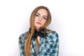 Headshot of a young adorable blonde woman in blue plaid shirt enjoying listening music to big professional dj headphones. Royalty Free Stock Photo