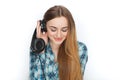 Headshot of a young adorable blonde woman in blue plaid shirt enjoying listening music to big professional dj headphones. Royalty Free Stock Photo