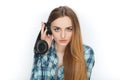 Headshot of a young adorable blonde woman in blue plaid shirt enjoying listening music to big professional dj headphones. Royalty Free Stock Photo