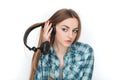 Headshot of a young adorable blonde woman in blue plaid shirt enjoying listening music to big professional dj headphones. Royalty Free Stock Photo