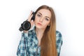 Headshot of a young adorable blonde woman in blue plaid shirt enjoying listening music to big professional dj headphones. Royalty Free Stock Photo