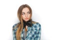 Headshot of a young adorable blonde woman in blue plaid shirt enjoying listening music to big professional dj headphones. Royalty Free Stock Photo