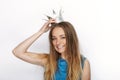 Headshot of young adorable blonde woman with cute smile in hand made princess crown on white background
