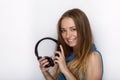 Headshot of young adorable blonde woman with cute smile wearing big black professional monitoring headphones against white studio Royalty Free Stock Photo