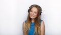 Headshot of young adorable blonde woman with cute smile wearing big black professional monitoring headphones against white studio Royalty Free Stock Photo