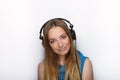 Headshot of young adorable blonde woman with cute smile wearing big black professional monitoring headphones against white studio Royalty Free Stock Photo