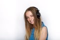 Headshot of young adorable blonde woman with cute smile wearing big black professional monitoring headphones against white studio Royalty Free Stock Photo