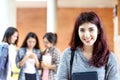 Headshot of young happy attractive asian student smiling and looking at camera with friends on outdoor university background.