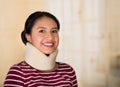 Headshot young hispanic woman posing wearing neck brace, smiling happily to camera, injury concept