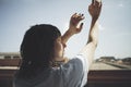 Headshot of young woman with hands up enjoying summer time.