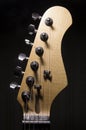 Headstock of an electric guitar on a dark background