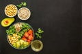 Healthy vegan lunch bowl. Avocado, quinoa, sweet potato, tomato, spinach and chickpeas vegetables salad on black table Royalty Free Stock Photo