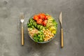 Healhty vegan lunch bowl. Avocado, quinoa, sweet potato, tomato, spinach and chickpeas vegetables salad on gray table Royalty Free Stock Photo