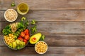 Healhty vegan lunch bowl. Avocado, quinoa, sweet potato, tomato, spinach and chickpeas vegetables salad on wooden table Royalty Free Stock Photo