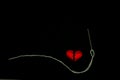 Healing broken heart concept  red heart is sewn with white thread with needle on black background Royalty Free Stock Photo