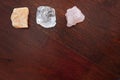 Healing crystals: Rose quartz, Calcite and a Clear quartz on a table. Gemstones are used for their positive vibrations to bring Royalty Free Stock Photo