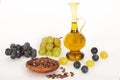 Healing grape seeds oil in a glass jar, fresh grapes on white background