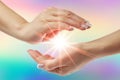 Healing hands with bright sunburst on rainbow background Royalty Free Stock Photo