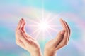 Healing hands with bright sunburst on rainbow background Royalty Free Stock Photo