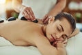 Healing with heat. an attractive young woman getting a hot stone massage at a beauty spa. Royalty Free Stock Photo