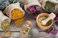 Healing herbs in hessian bags, wooden mortar with chamomile