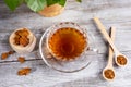 Healing infusion of birch mushroom chaga in figured glass cup and chaga pieces on wooden table. Alternative medicine