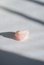 Healing rose crystal or a gemstone on a white table. A lovely pink love stone isolated bring good vibes and positive vibrations