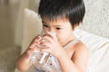 health and beauty concept - Asian little girl holding and drinking a glass of water