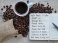 Health benefits of coffee - words handwritten in a notepad. A rustic bag with spilled coffee beans and a cup of coffee