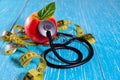 Health care check up and Lose weight for health. Tape measure for body, apple and Stethoscope on wooden desk Royalty Free Stock Photo