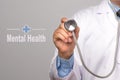 Health Care Concept. Doctor holding a stethoscope and Mental Health word on gray background.