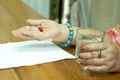 Health care concept fat senior woman hand holding pills with glass of water Royalty Free Stock Photo