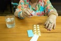 Health care concept fat senior woman hand holding pills and glass water Royalty Free Stock Photo