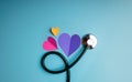 Health Care Concept. International World Heart Day. Paper Cut as Heart Shape with Stethoscope lay on Blue background