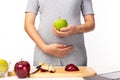 Health care concept. Pregnant mother hold green apple or fruit for eating. It is healthy food for fetus, pregnant woman. Mom care Royalty Free Stock Photo