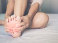 Woman massaging her painful foot, red hi-lighted on pain area Royalty Free Stock Photo