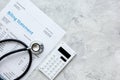 Health care costs with billing statement, stethoscope and calculator on stone table top view mockup Royalty Free Stock Photo