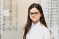 Health care, eyesight and vision concept - happy woman choosing glasses at optics store. Portrait of beautiful young Royalty Free Stock Photo