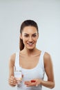 Health Care And Medicine Concept. Portrait Of Beautiful Smiling Young Woman With Handful Of Vitamin Pills. Royalty Free Stock Photo