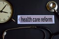 Health care reform on the print paper with Healthcare Concept Inspiration. alarm clock, Black stethoscope.