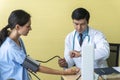 Health care sickness concept. Professional doctor young man with stethoscope testing blood pressure for patient woman while Royalty Free Stock Photo